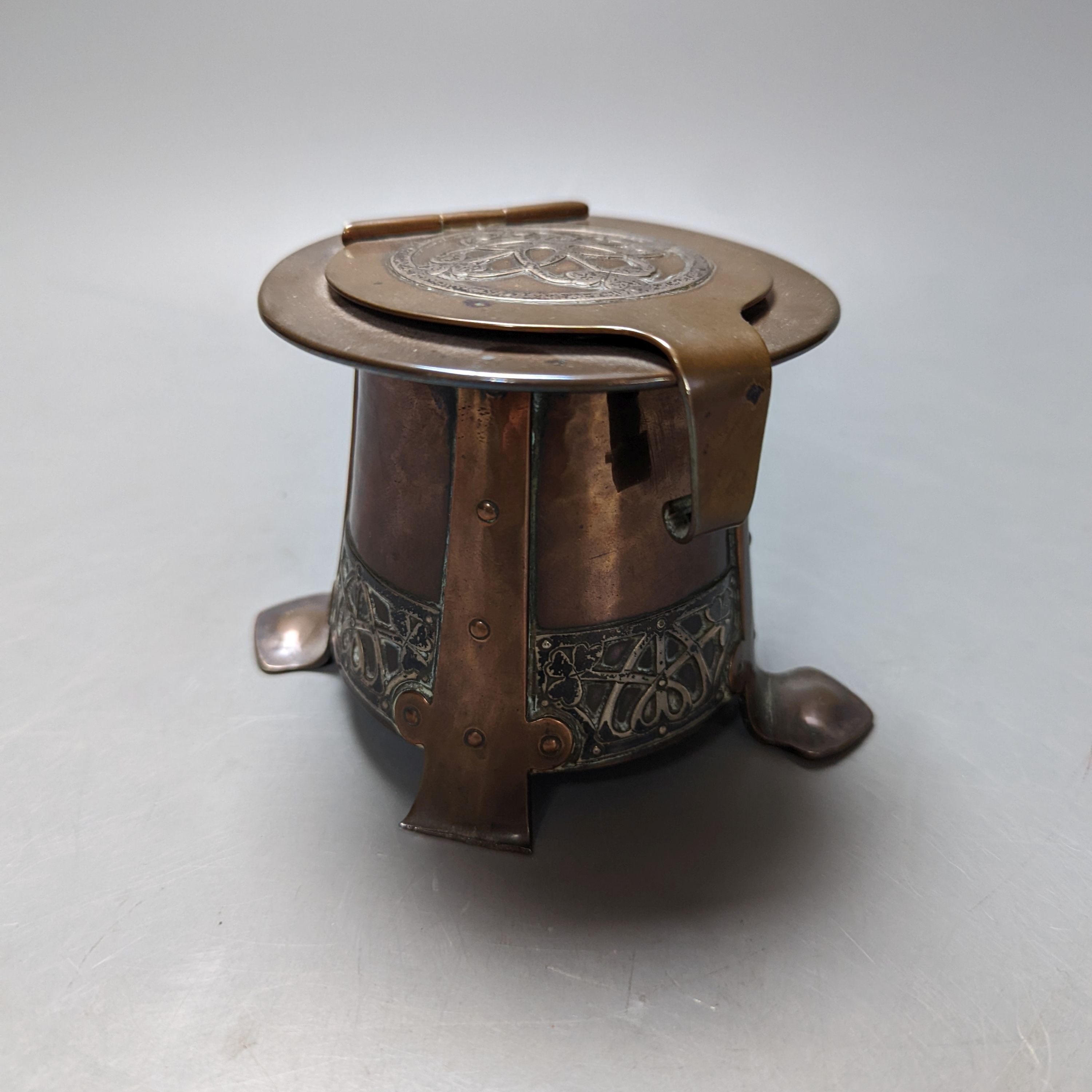 An Arts and Crafts copper and white metal inkwell, unsigned, 9 cms high.